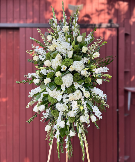 Sacred Purity Spray with white roses, orchids, hydrangea, calla lilies, gladioli, stock, and lush greens for a large funeral tribute.