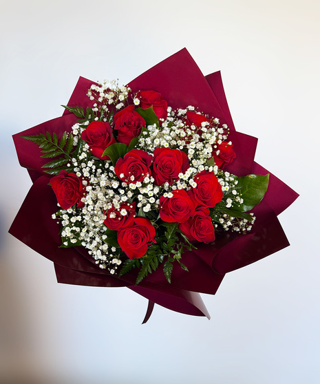 Hand-wrapped bouquet of 12 long-stem Ecuadorian roses in assorted colors accented with baby’s breath, lemon leaf, and leather leaf