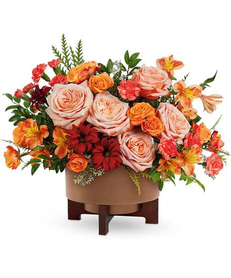 Copper Celebration Bouquet with peach roses, orange spray roses, mini-carnations, alstroemeria, and bronze daisies in a copper planter with stand