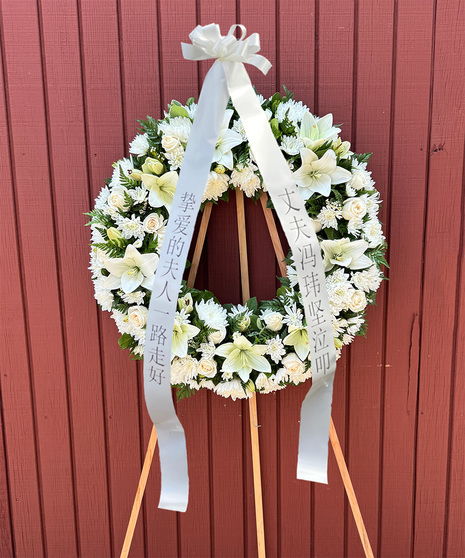 All-white Funeral Wreath with Asiatic lilies, roses, carnations, and cushion mums on a 5.5-foot stand with greenery